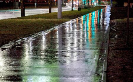 There is a wet empty street of the city after the night rainの写真素材