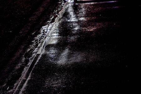 There is asphalt road after rain at night.Black and white imageの写真素材