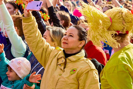 March 8, 2019 Minsk Belarus Women's Day Race on March 8. Young women with yellow hair and clothes take pictures on the phoneのeditorial素材