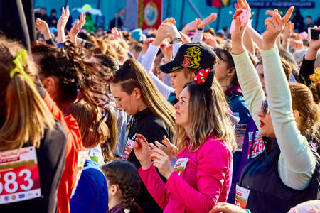 March 8, 2019 Minsk Belarus Women's Day Race on March 8 There are young women with their hands raised at a concertのeditorial素材