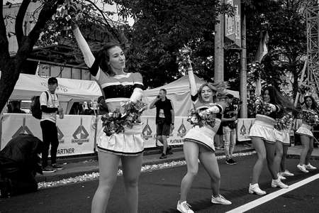 September 15, 2019 Minsk Belarus In black and white before the start of the marathon perform sports dancers cheerleaders with large bows in their handsのeditorial素材