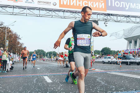September 9, 2018 Minsk Belarus Half Marathon Minsk 2018 The competitor crossed the finish line looking at the smart watch on his hand that monitors his heart rateのeditorial素材
