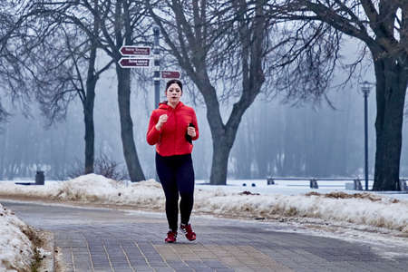 February 9, 2019 Minsk Belarus Run dedicated to February 14 A woman runs in the winter in a city Parkのeditorial素材