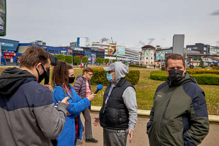 May 24 2020 Minsk Belarus Collecting votes for opposition candidates to participate in the elections on the street where two men answer questions from correspondentsのeditorial素材