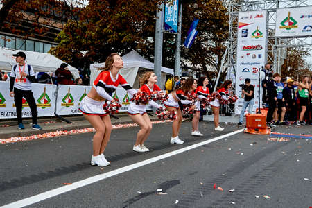 September 15, 2019 Minsk Belarus Beautiful girls dance from support groups with large bows in their hands when the photographer takes them offのeditorial素材