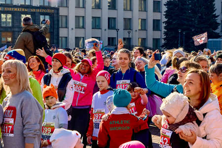 March 8, 2019 Minsk Belarus Women's Day Race on March 8. There are happy women with their hands up at a concert and a photographer with a cameraのeditorial素材