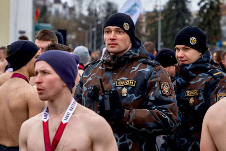 February 23, 2019 Minsk Belarus The race in honor of the holiday on February 23 Two strong cheerful policemen stand among men with naked torsosのeditorial素材