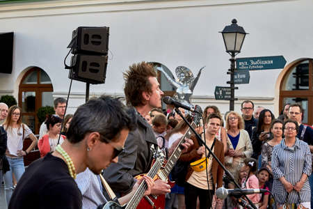 June 1, 2019 Minsk Belarus Three musicians play in front of a crowd of people on the streetのeditorial素材