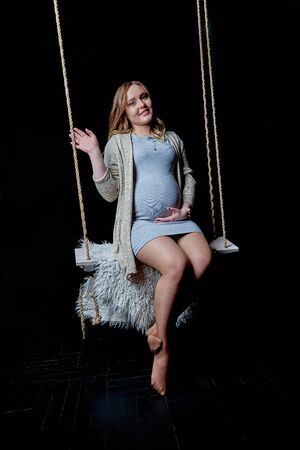 The pregnant woman stands on a black backgroundの写真素材