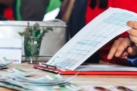 Close up before the start of the night race volunteers prepare documents for participantsの写真素材