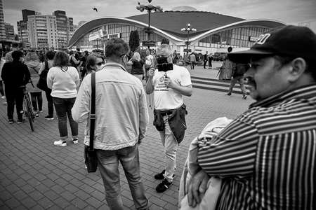 June 7 2020 Minsk Belarus In the black-and-white image, masked opposition blogger Nikolai Maslovsky is broadcasting live on the street in front of people standing in lineのeditorial素材
