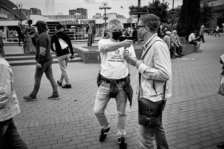 June 7 2020 Minsk Belarus Masked opposition blogger Nikolai Maslovsky is broadcasting live on the street using his phone asking the man questionsのeditorial素材