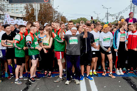 September 15, 2019 Minsk Belarus A happy old athlete raised his hands in front of a crowd of young athletesのeditorial素材