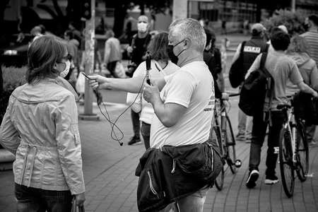 June 7 2020 Minsk Belarus Opposition blogger Nikolai Maslovsky is broadcasting live on the street asking a woman questionsのeditorial素材