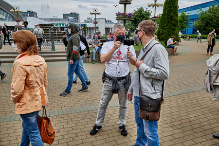 June 7 2020 Minsk Belarus Masked opposition blogger Nikolai Maslovsky is broadcasting live on the street asking the man questionsのeditorial素材