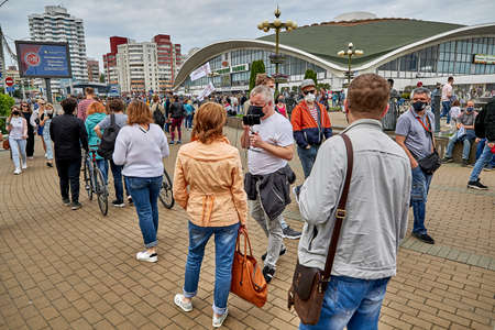 June 7 2020 Minsk Belarus Masked opposition blogger Nikolai Maslovsky is broadcasting live on the street asking a woman questions as she stands in lineのeditorial素材