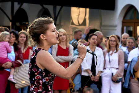 May 25, 2019 Minsk Belarus A theatrical performance in which a close-up of a beautiful woman with a microphone sings on the streetのeditorial素材
