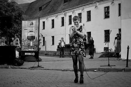 May 25, 2019 Minsk Belarus Street concert in which a beautiful Caucasian woman sings in the evening on the street.Black and white imageのeditorial素材