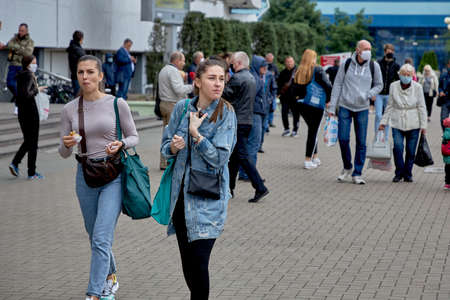 June 14 2020 Minsk Belarus Two young women are walking down a city street eating fast foodのeditorial素材