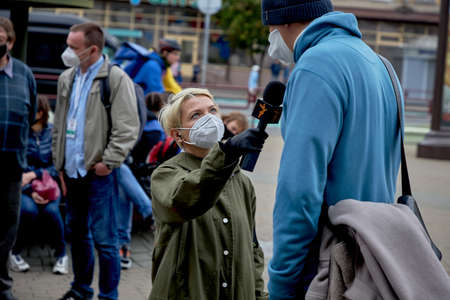 June 14 2020 Minsk Belarus A female reporter with a microphone is talking to a tall man on the streetのeditorial素材