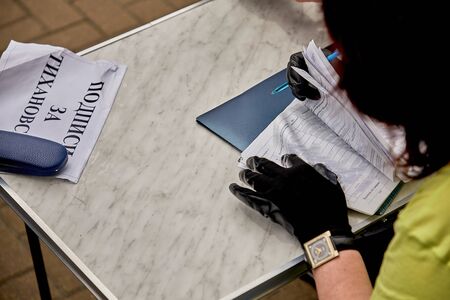 June 7 2020 Minsk Belarus A woman in gloves casts her vote for a presidential candidateの写真素材