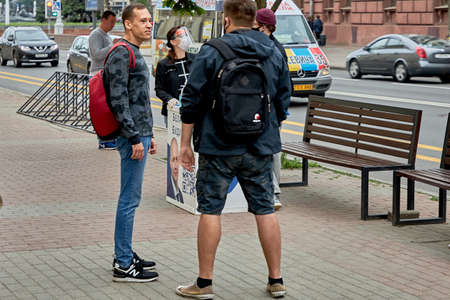 June 14 2020 Minsk Belarus Walking people talk next to the signature collection tableのeditorial素材