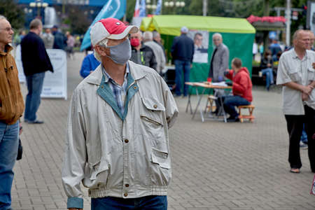 June 14 2020 Minsk Belarus An elderly man in a mask is walking along a city streetのeditorial素材