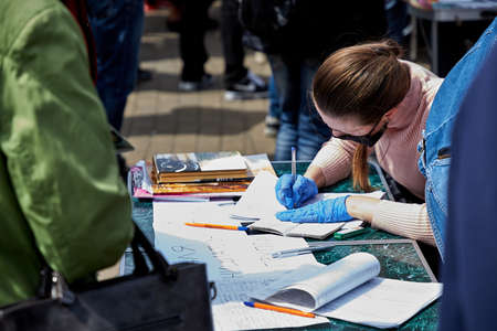 May 24 2020 Minsk Belarus A woman from the presidential candidate's initiative group fills out a questionnaire according to her passport .のeditorial素材