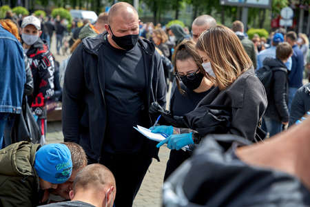 May 24 2020 Minsk Belarus A woman tells masked people how to fill out subscription lists for an alternative presidential candidateのeditorial素材