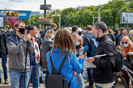 May 24 2020 Minsk Belarus. A reporter with a microphone asks questions to a man collecting signaturesのeditorial素材