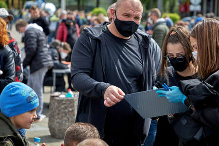 May 24 2020 Minsk Belarus A woman tells a masked couple how to fill out subscription lists for an alternative presidential candidateのeditorial素材