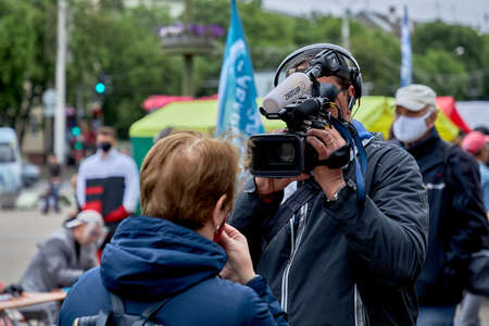 June 14 2020 Minsk Belarus An operator with a large camera takes a close-up of a womanのeditorial素材