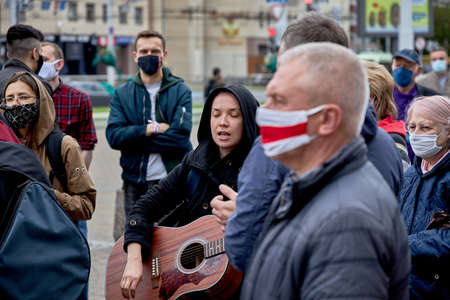 June 14 2020 Minsk Belarus A young woman plays a guitar and sings with her eyes closed during a protest against the current governmentのeditorial素材