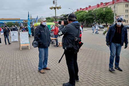 June 14 2020 Minsk Belarus A cameraman with a large camera films a masked man during a protestのeditorial素材