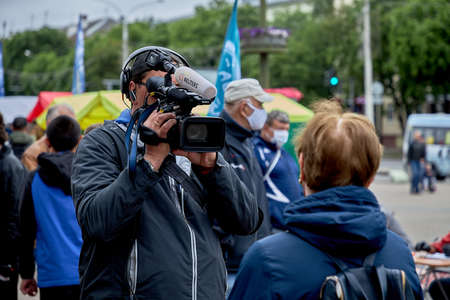 June 14 2020 Minsk Belarus An operator with a large camera takes a close-up of a mature womanのeditorial素材