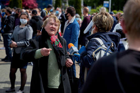 May 24 2020 Minsk Belarus. An elderly woman tells a reporter with a microphone about her difficult lifeのeditorial素材
