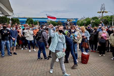 June 7 2020 Minsk Belarus A rally when a masked woman walks with a small opposition flag in her handのeditorial素材