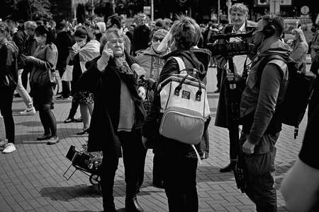 May 24 2020 Minsk Belarus. In the black and white image a female reporter and cameraman with a large camera interview a mature woman during a protestのeditorial素材