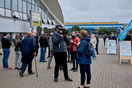 June 14 2020 Minsk Belarus An operator with a large camera takes a close-up of a womanのeditorial素材