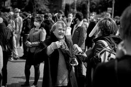 May 24 2020 Minsk Belarus. An elderly woman tells a reporter with a microphoneのeditorial素材
