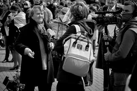 May 24 2020 Minsk Belarus A female reporter and cameraman with a large camera film a mature woman during a protestのeditorial素材