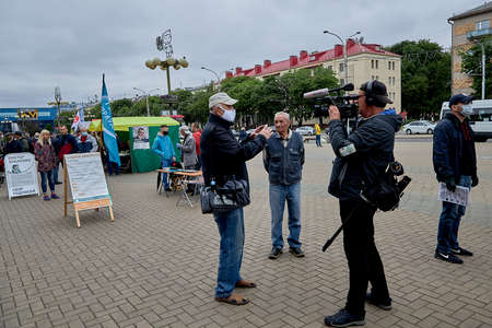 June 14 2020 Minsk Belarus An operator with a large camera takes pictures of a simple Belarusian citizen during a protest actionのeditorial素材