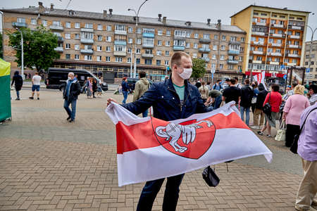 June 7 2020 Minsk Belarus On the square stands a young man in a mask with the flag of the oppositionのeditorial素材