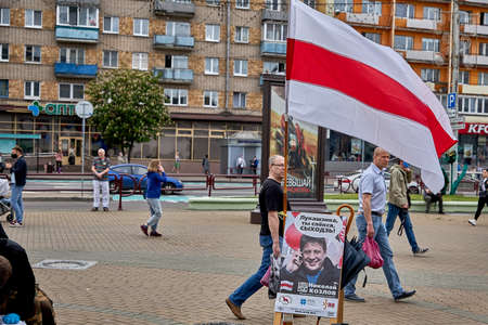 June 7 2020 Minsk Belarus People walk next to the waving flag of the opposition and a poster of the presidential candidateのeditorial素材