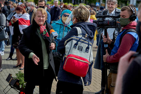 May 24 2020 Minsk Belarus. A female reporter and cameraman with a large camera interview a mature woman during a protestのeditorial素材