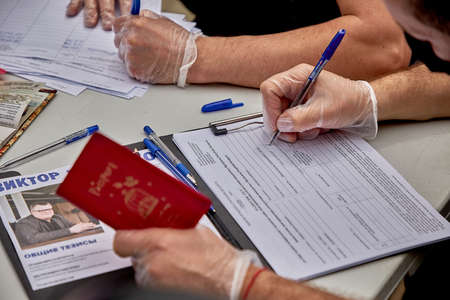 June 7 2020 Minsk Belarus A masked man fills out a presidential candidate's signature listのeditorial素材