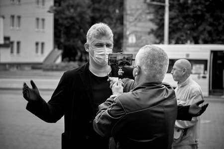 June 14 2020 Minsk Belarus There is a portrait of a masked man answering questions from a blogger during a protestのeditorial素材