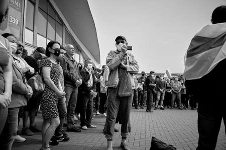 June 7 2020 Minsk Belarus A rally where a Mature man with a phone takes photos of people standing in protestのeditorial素材