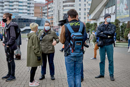 June 14 2020 Minsk Belarus A reporter with a microphone and a man with a camera interview a masked woman at a protest rallyのeditorial素材
