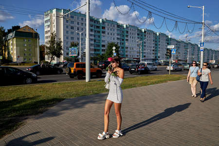 August 15 2020 Minsk Belarus A young woman with a red rose talking on the phoneのeditorial素材
